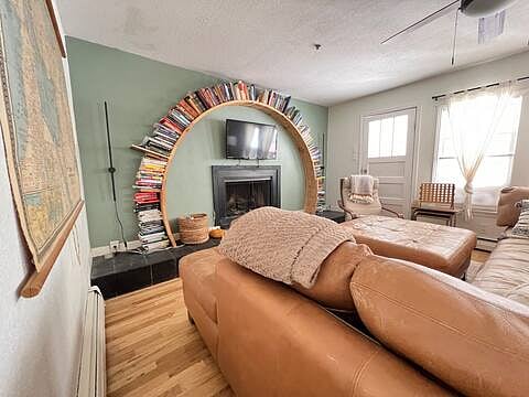 The living room boasts of a cozy wood burning fireplace with a one of a kind bookshelf. 
