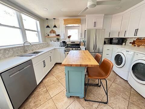 Kitchen includes gas range stove, dishwasher and washer and dryer unit. 