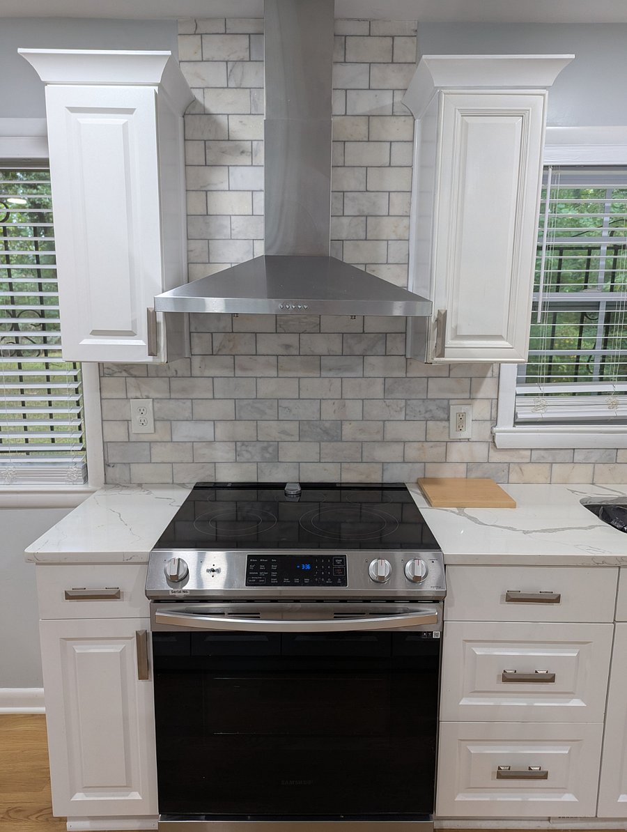 New electric oven/stovetop with large range hood.