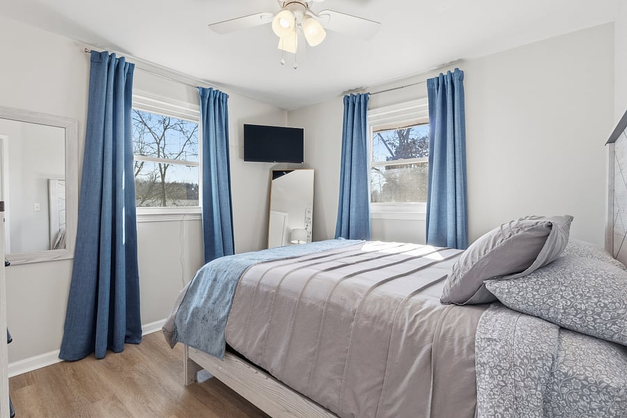 Back bedroom also features a Roku smart TV and a ceiling fan.
