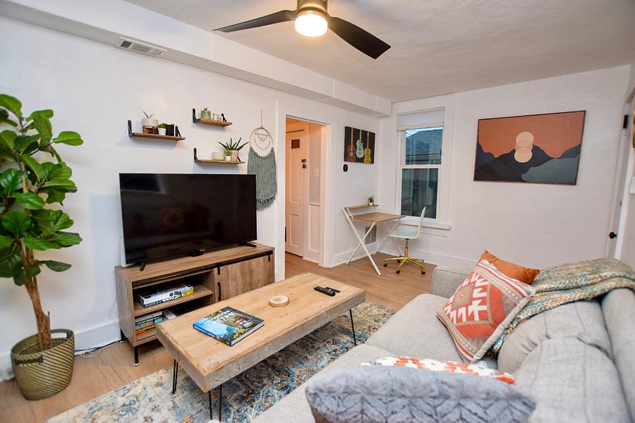Living room showing TV, table, desk, etc. The open doorway goes to the kitchen
