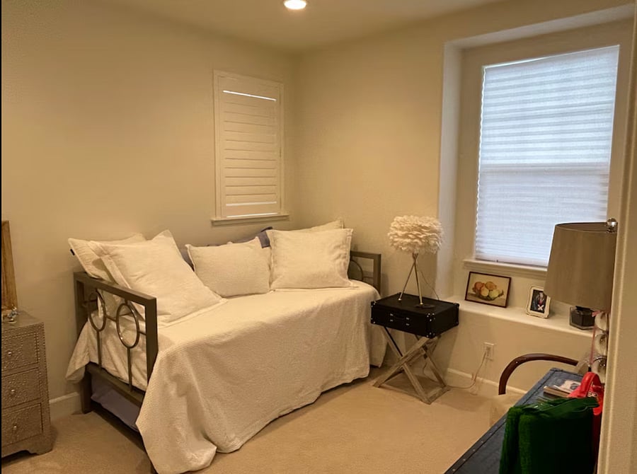 Private light-filled bedroom with plantation shutters and twin trundle bed.