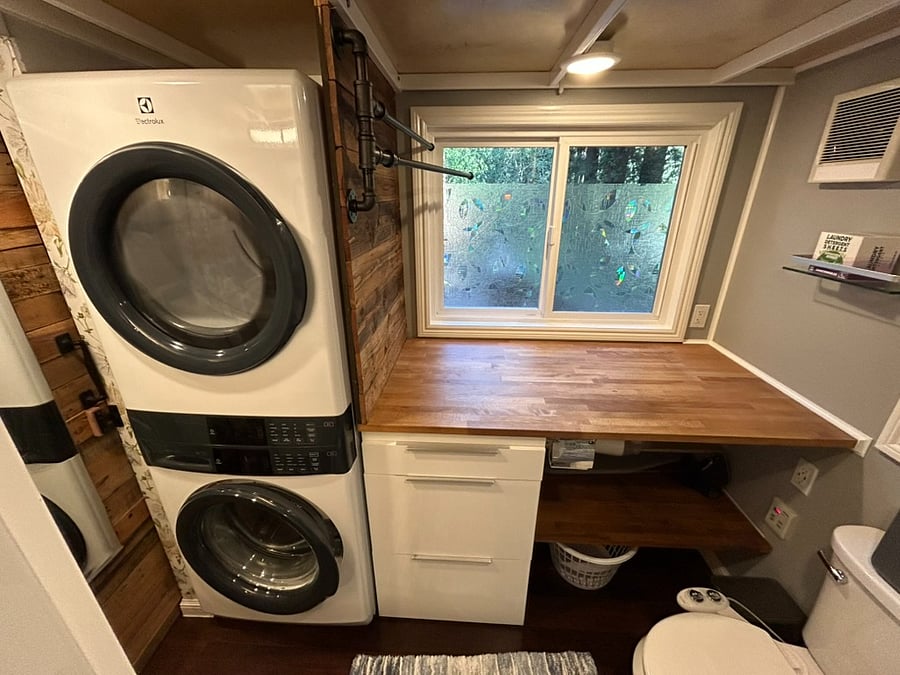 The bathroom includes a full size washer/dryer, folding table with under counter storage.