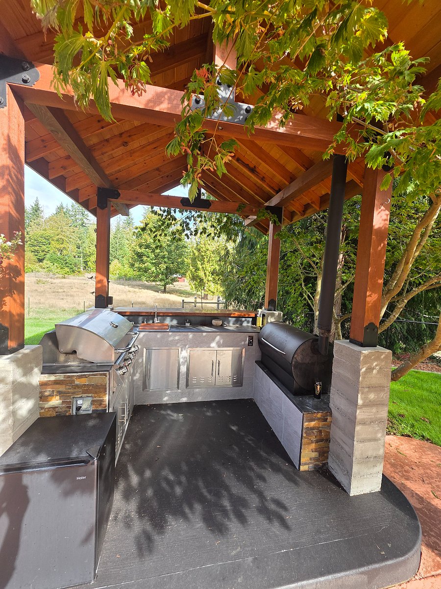 Fully appointed outdoor kitchen with gas grill, traeger smoker, sink, and outdoor fridge, available for tenant use at any time.