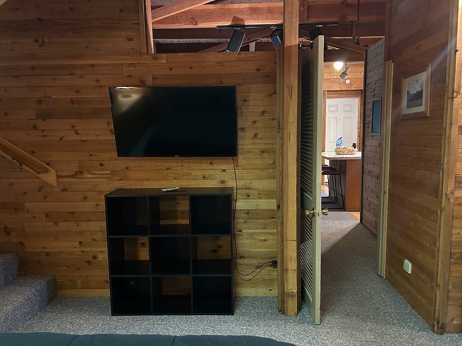 Bedroom: Mounted TV, extra shelves, and bedroom entryway