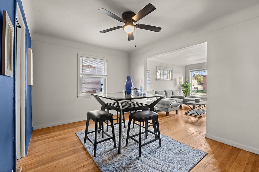 Modern dining room with sleek table, blue accent wall, and natural light ideal for dining, work, or relaxing at the end of the day.
