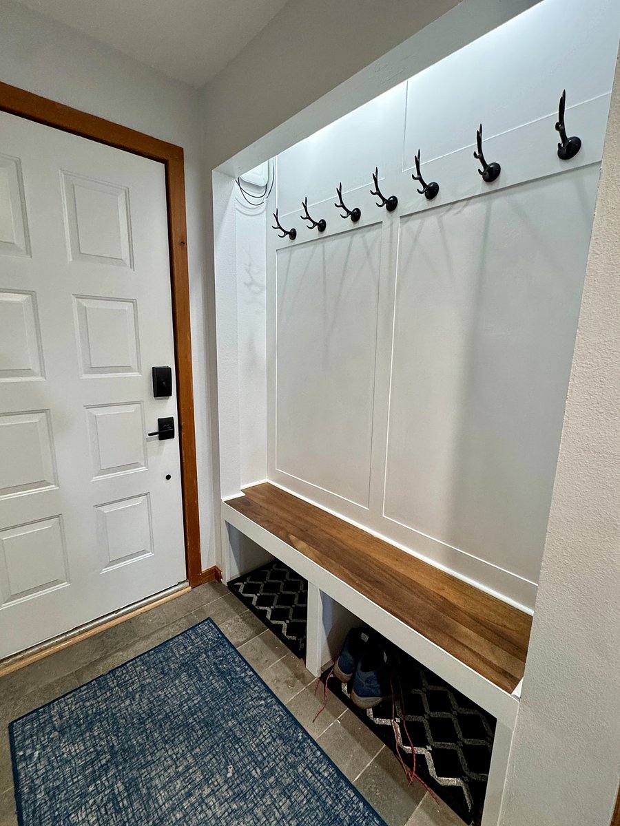 Entry with bench/mud area with boot bins and hooks for coats.