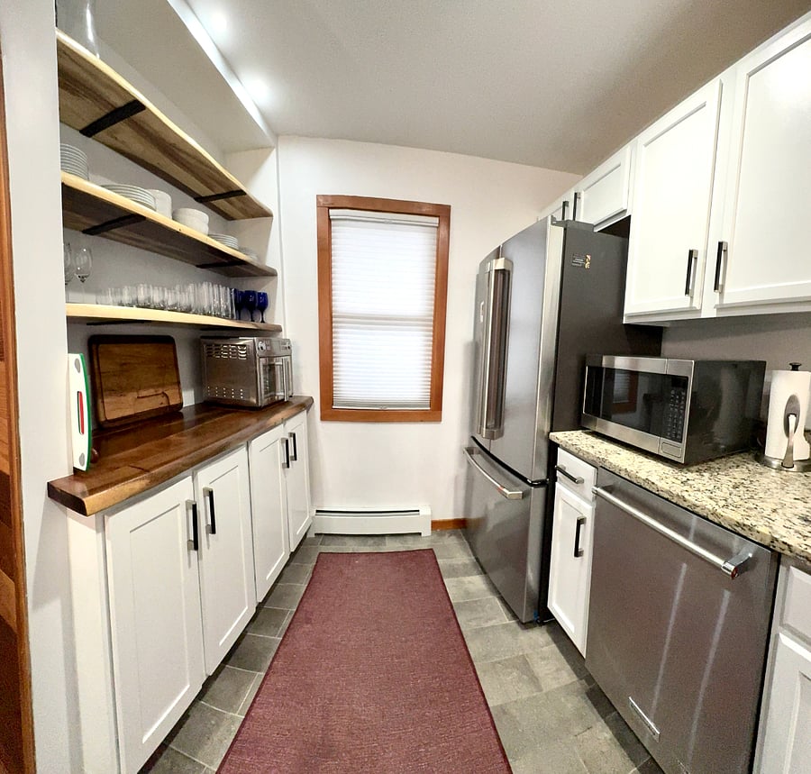 Custom built kitchen floor to ceiling built-ins with hidden trash and storage, Emeril Oven/Air Fryer to the left and microwave to the right + dishwasher and Cafe refrigerator.