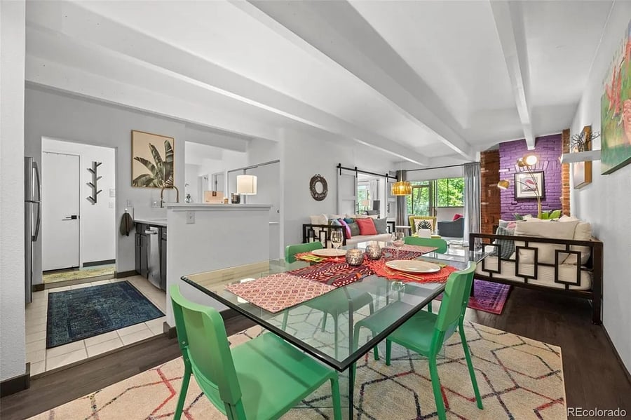 View of the space from the dining room with kitchen to the left, while inviting view of living room and sun room beyond.