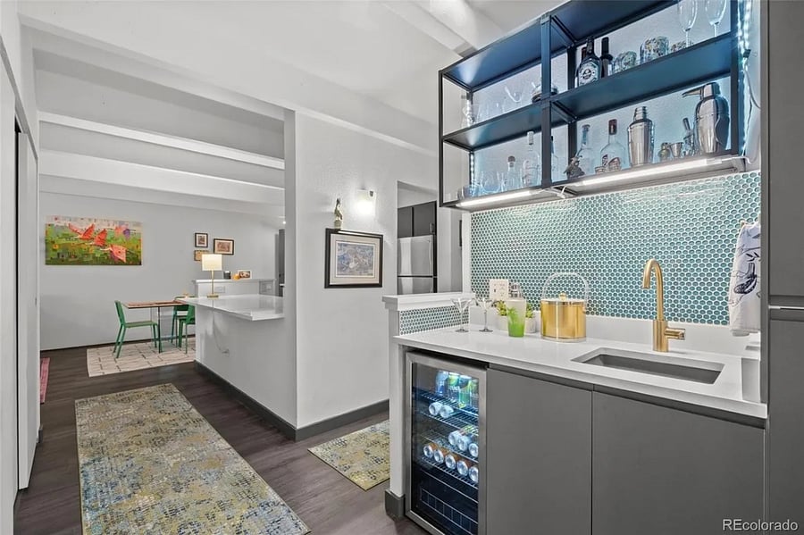 Wet bar in hallway with kitchen and dining room visible in background.