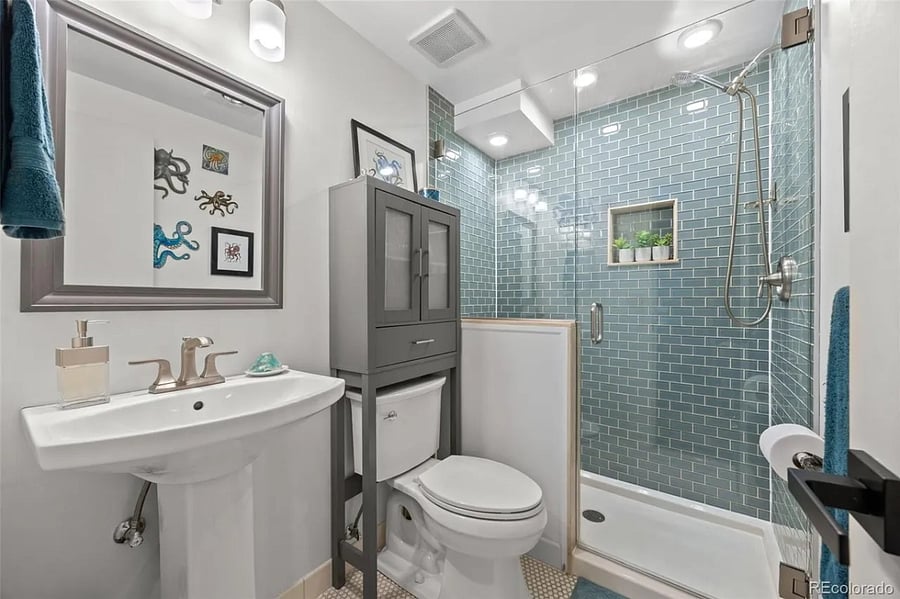Bathroom with pedestal sink, stool and walk-in shower