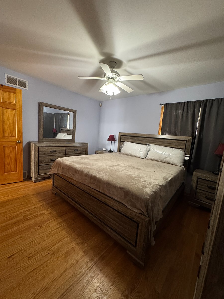 Primary bedroom features a king-size bed, ceiling fan, and full, private, en-suite bathroom.