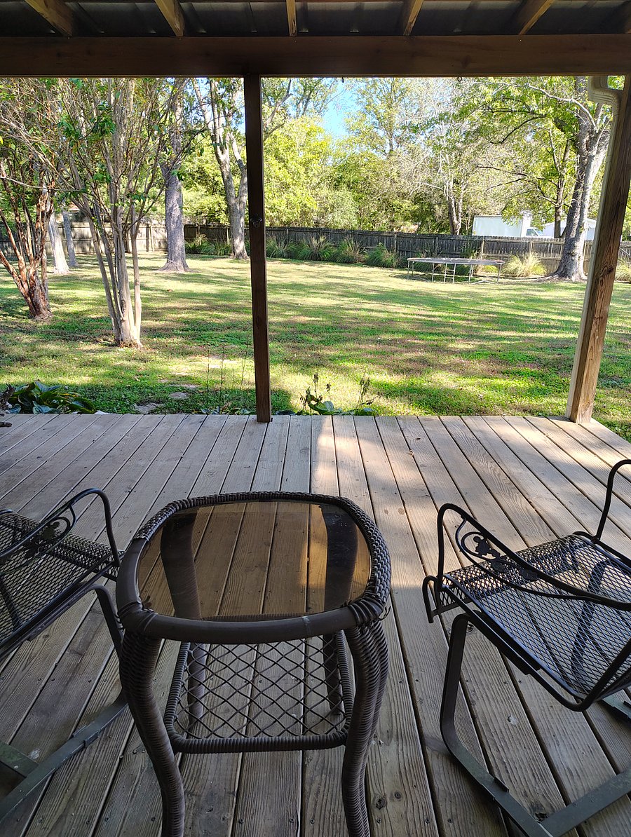 Shared covered back deck overlooking large fenced-in back yard.