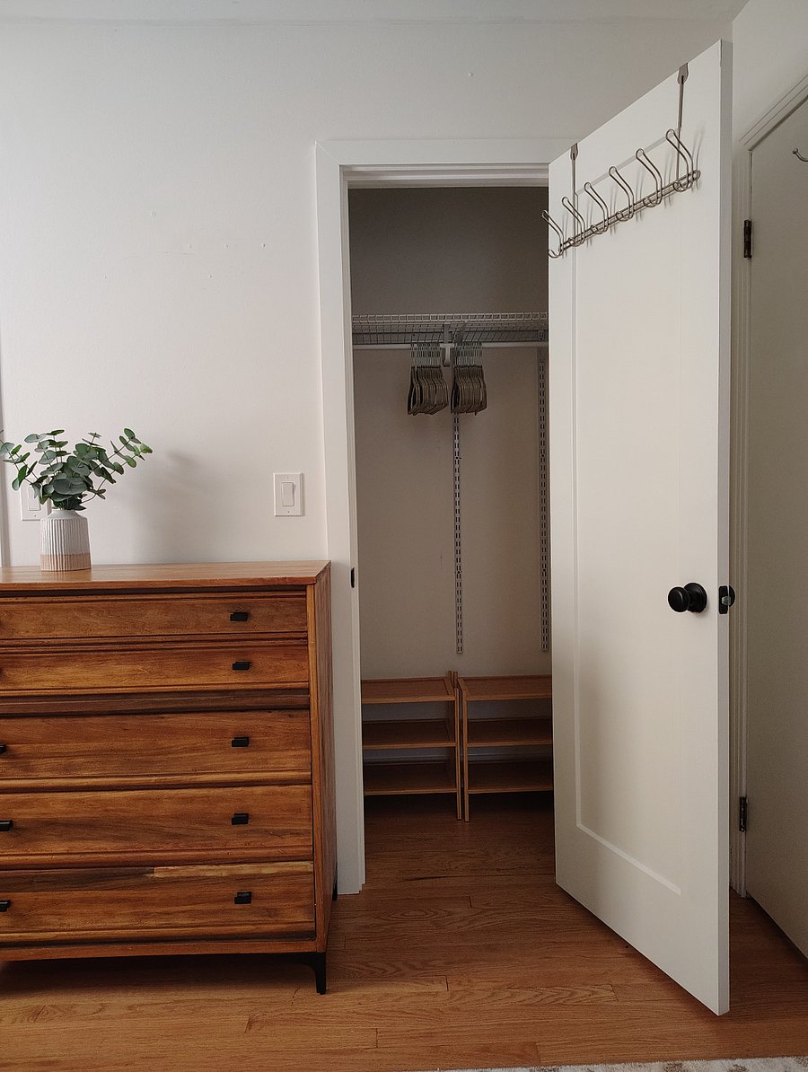 Closet with wooden shoe racks and hangers.