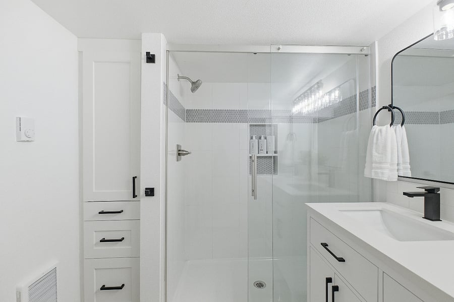 Large walk-in tiled shower with glass doors. Lots of storage space in cupboards and drawers. 