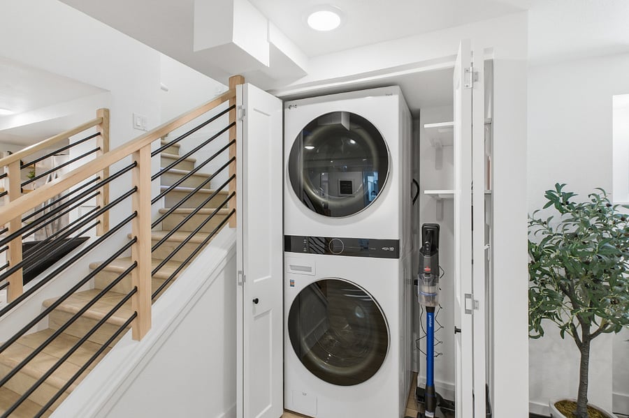 New tower washer and dryer behind bi-fold doors. 