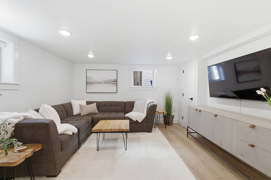 Living room, with comfortable sectional and wall mounted 55" streaming ready TV.