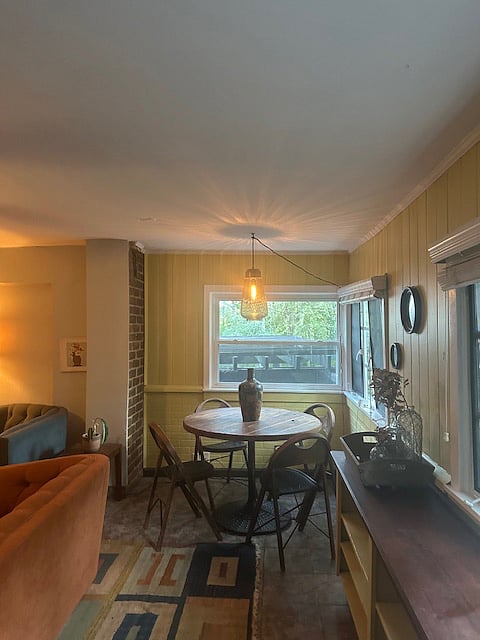 Dining area with beautiful windows and views of plants/trees.