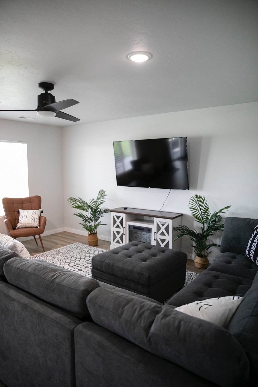 Downstairs living room with electric fireplace and 2 chairs in front of the 2 big bright windows with a center table :) 