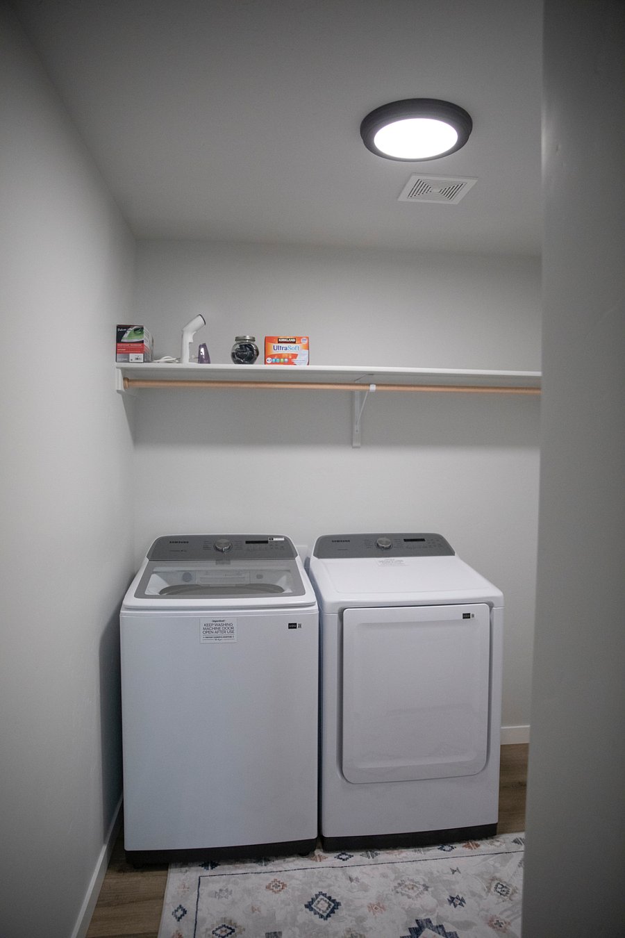Laundry room with full washer and dryer. Hand steamer, iron and ironing board. 