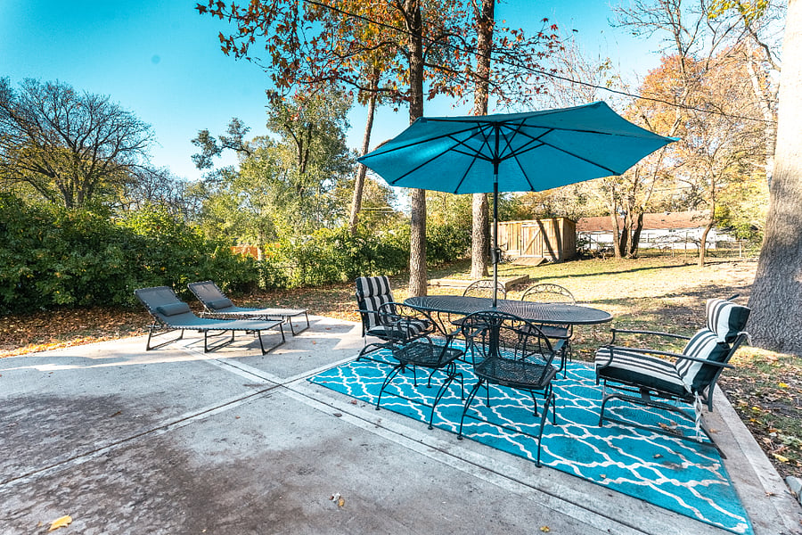 Large fenced backyard with cement patio and outdoor seating. Perfect for dinner outside, kids to run around & play or pets to explore.