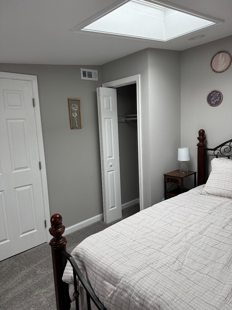 Nightstand, lamp, and closet with plenty of storage space.