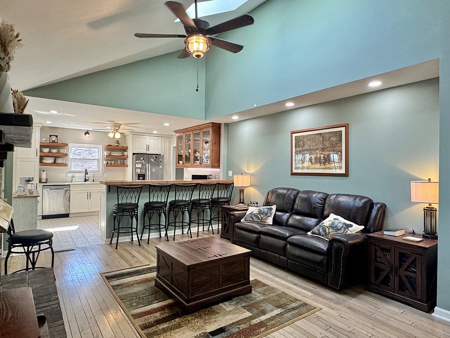 Den opens up into the kitchen with additional bar seating.