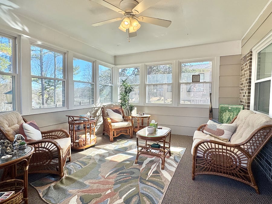 The sunroom is located off of the den  and kitchen area.