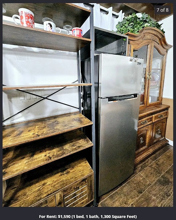 The kitchenette has a stainless steel fridge, a black mini-fridge, microwave, and space for groceries, dishes, etc.