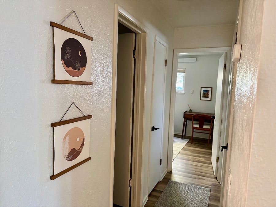 Hallway off the living room leading to the bedrooms, bathroom, and two linen/storage closets.