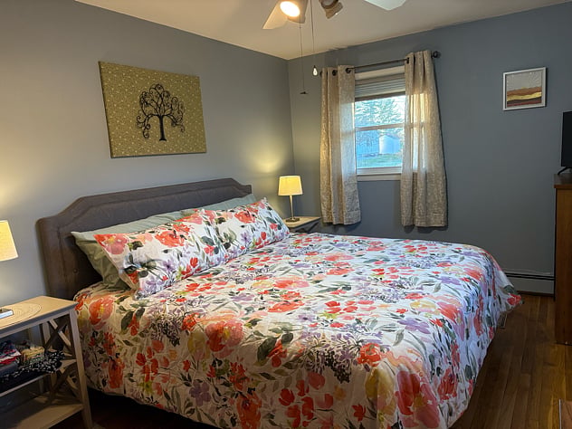 Primary bedroom with king-sized bed with 2 dressers and a smart TV