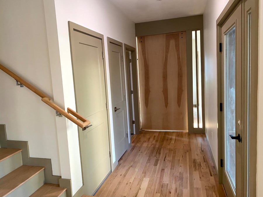 Hallway off the open concept 1st floor leading to the 1st full bathroom as well as the private study inclusive of a pull out couch and quiet work space.