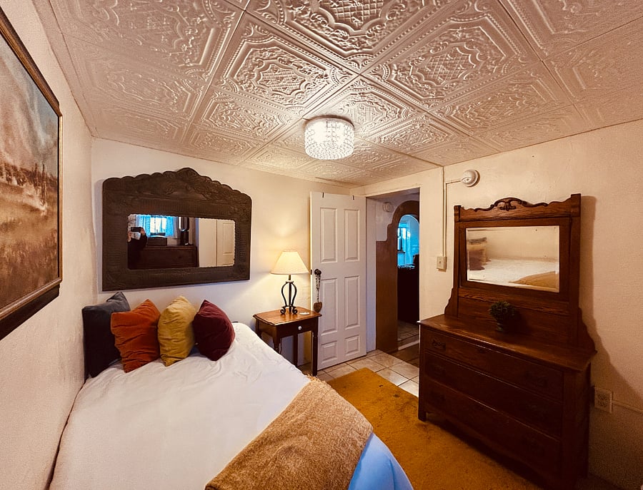 Dashing guest room with a twin bed, rug, closet, and two large chest of drawers. This room is located near the king room.