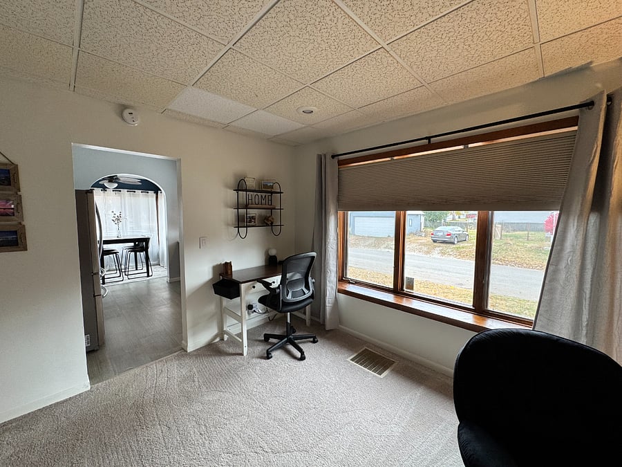 Desk in living room next to large window with plenty of natural light