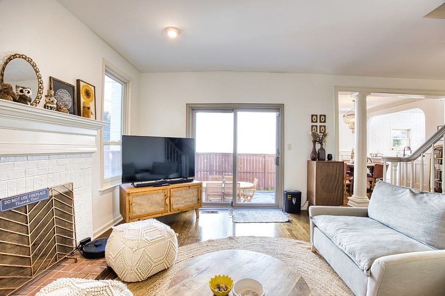 From the living room look outside towards the paver patio and outdoor living space