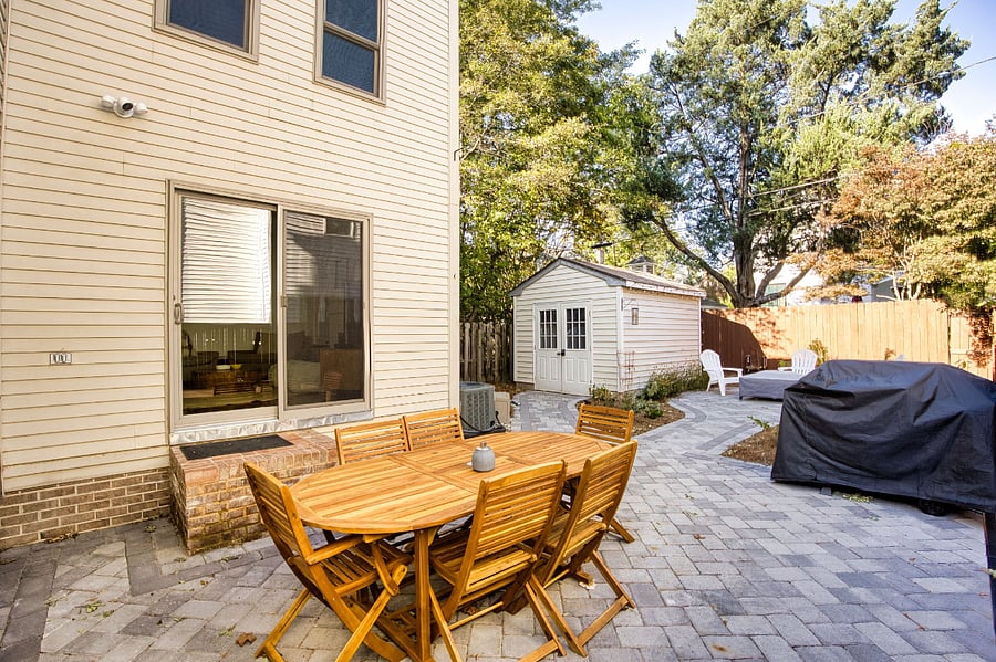 Paver stone back yard with gas grill, dining area and firepit.
