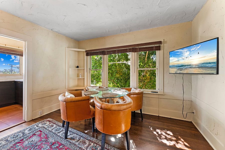 Dining table, Smart TV, windows that look on to Madison Street. Wood blinds for privacy, and mini split (you can't see it but it's there behind the table).