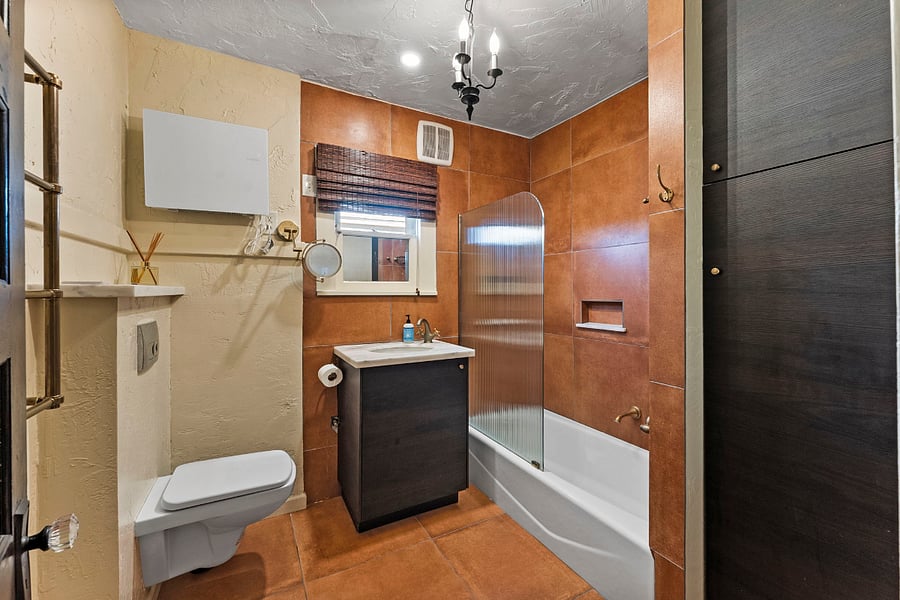 Full bath: Tub, shower, sink, storage cabinets, wall heater and European style wall mounted toilet.