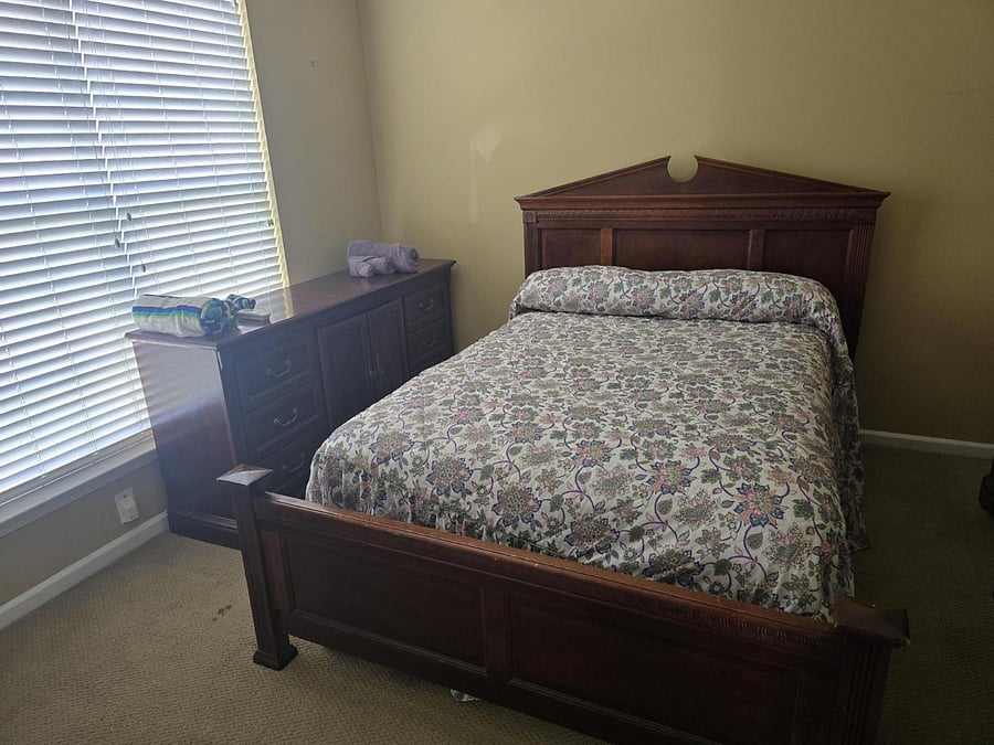 Bedroom 2: Queen bed, light beige walls, classic dark wood set, dresser, and cozy bedding.