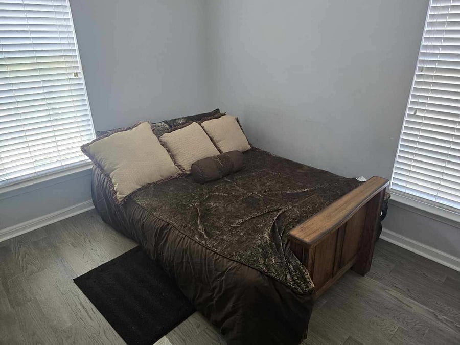 Bedroom 3: Full bed, calming gray walls, soft lighting  ideal for rest or a home office setup.