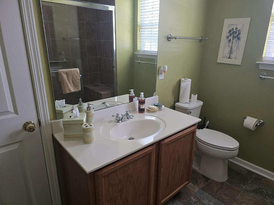 The primary ensuite offers a walk-in shower, large mirror, and modern fixtures.