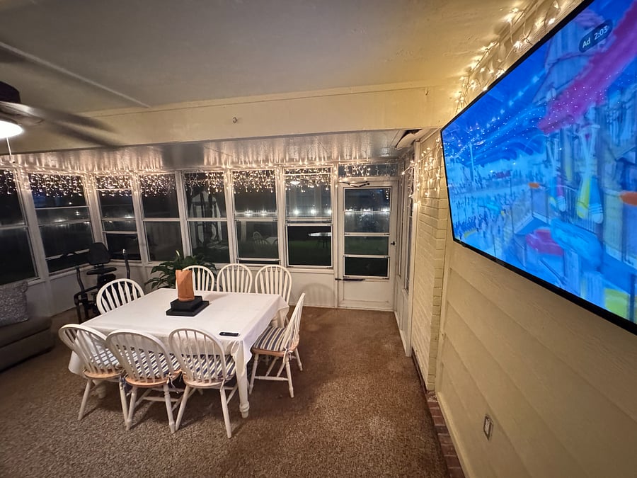 Inviting sunroom with smart TV , hammock, and seating a perfect spot to unwind or enjoy the view.