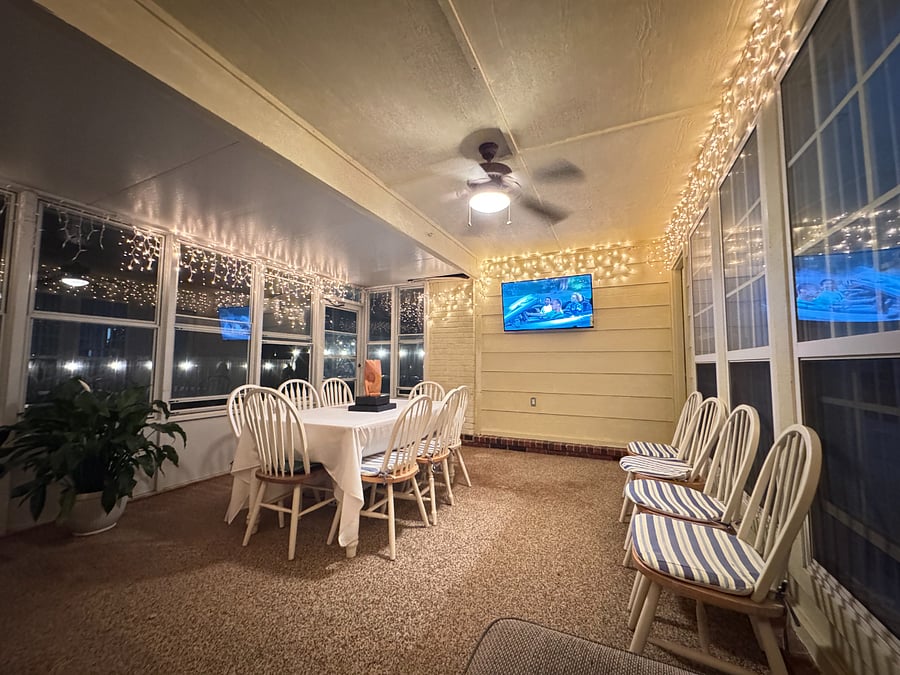 Inviting sunroom with smart TV , hammock, and seating a perfect spot to unwind or enjoy the view.