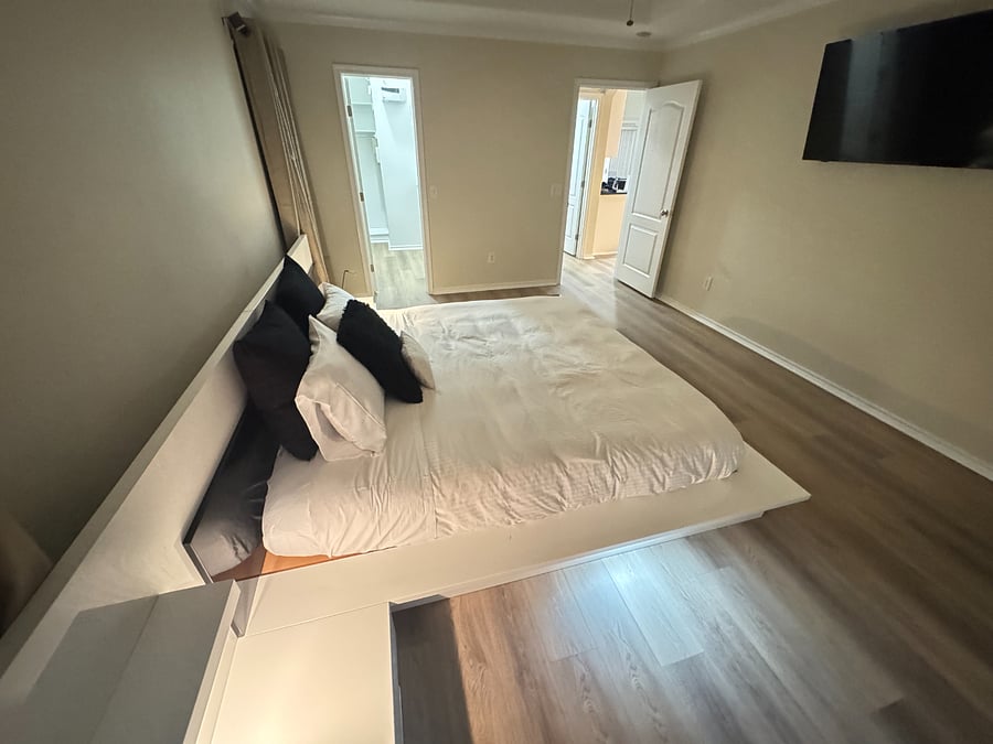 Relaxing master bedroom with smart TV, California king bed, and ample closet space.