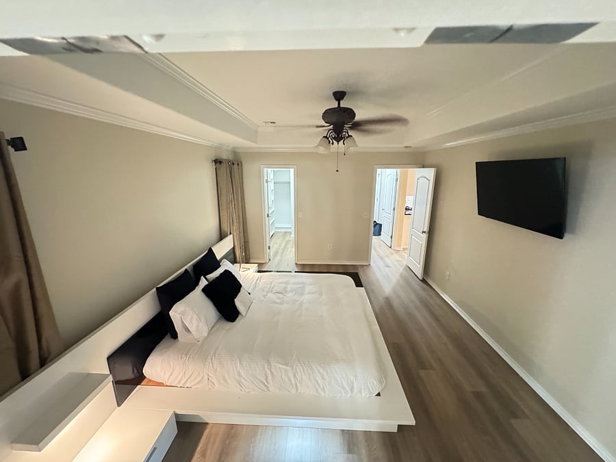 Relaxing master bedroom with smart TV, California king bed, and ample closet space.