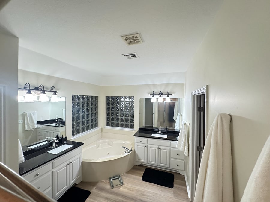 Spacious master bath with dual sinks, private shower, relaxing bathtub, and natural light for a bright, comfortable feel.