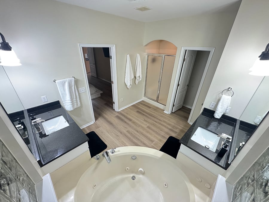 Spacious master bath with dual sinks, private shower, relaxing bathtub, and natural light for a bright, comfortable feel.