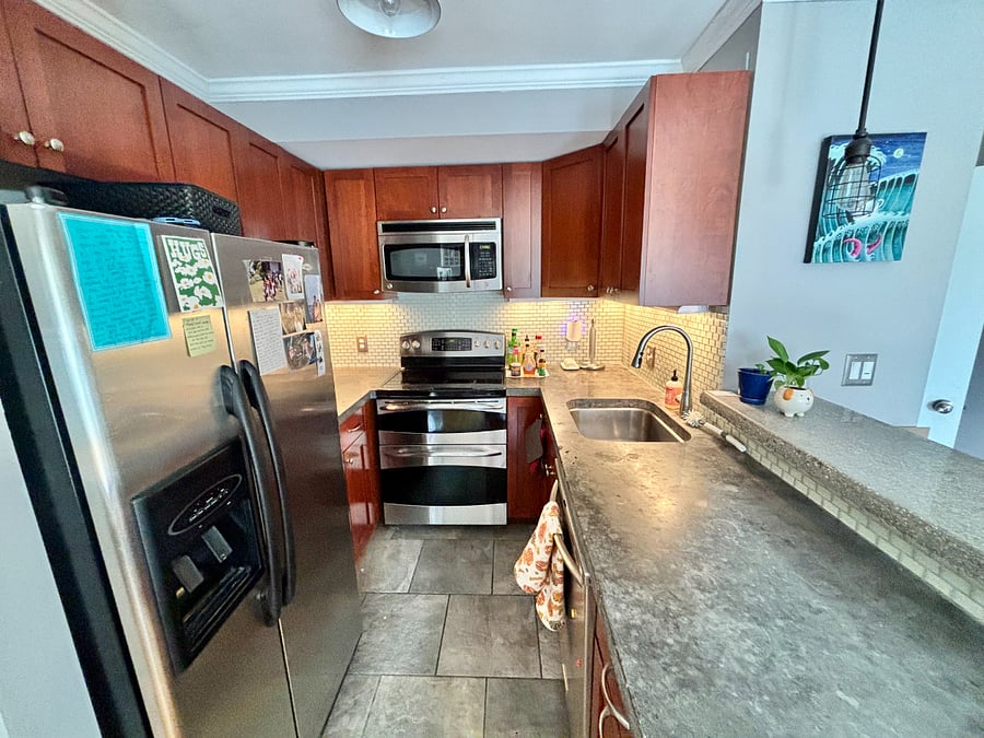 Updated kitchen with granite countertops, attractive tiles and cherry wood cabinetry