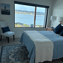Bedroom with shades and view of water.