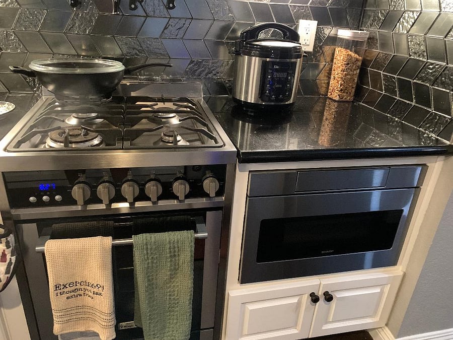 Kitchen. Comes with all utensils and dishes, spices, starter food supplies, including dried and canned staples. Features a large fridge, a tucked-in microwave, Brita water filter, toaster, oven, stove, and coffee maker. Ample storage for tenants' food goods in kitchen cabinets and in the walk-in pantry.